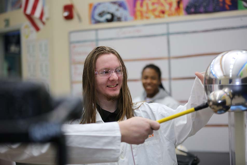 student in classroom smiling at camera